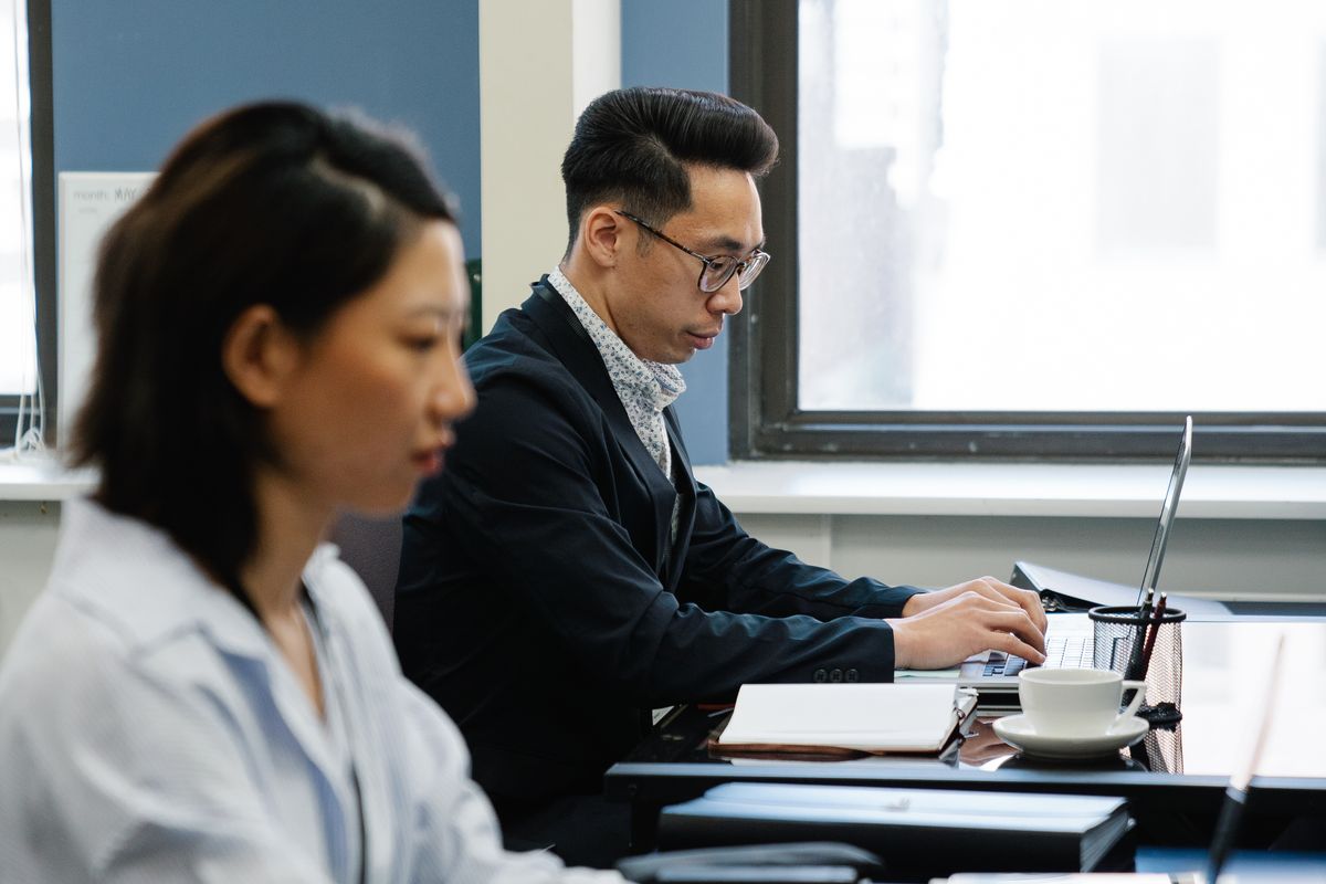 Two colleagues going through work on a laptop