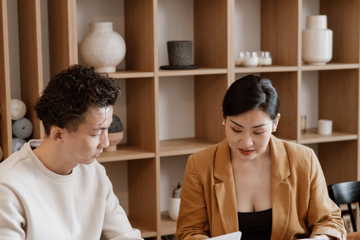 Coworkers comparing notes at a desk